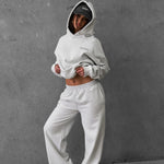 a girl wearing a grey hoodie and pants against a gray background